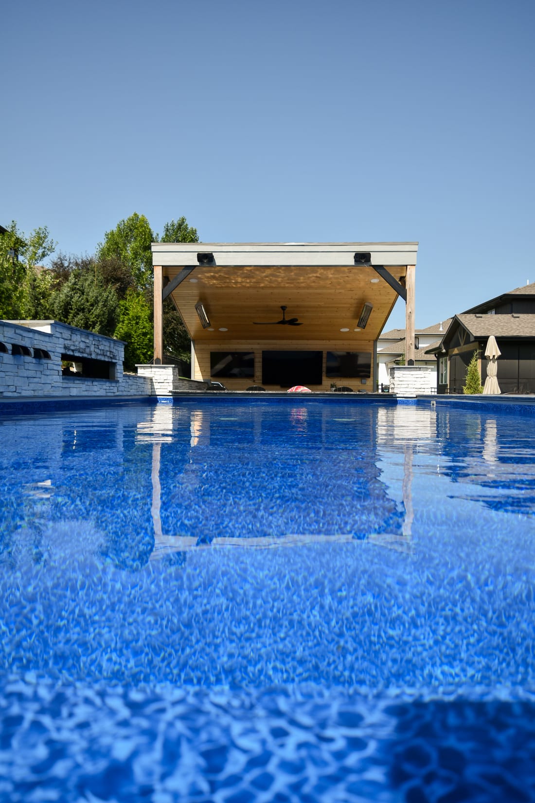 Dark-bottom swimming pool and spa in a landscaped backyard