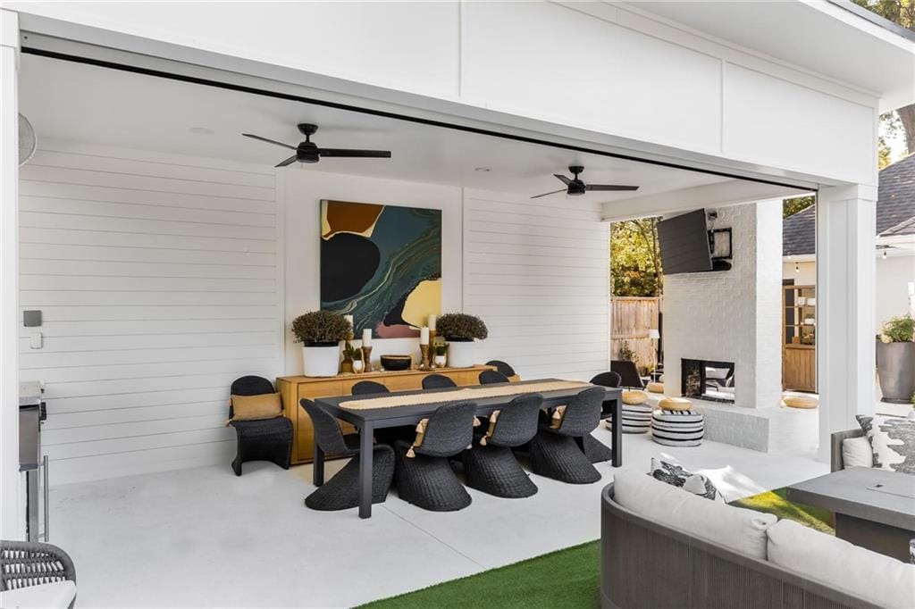 Covered outdoor living room with a dining table and ceiling fans