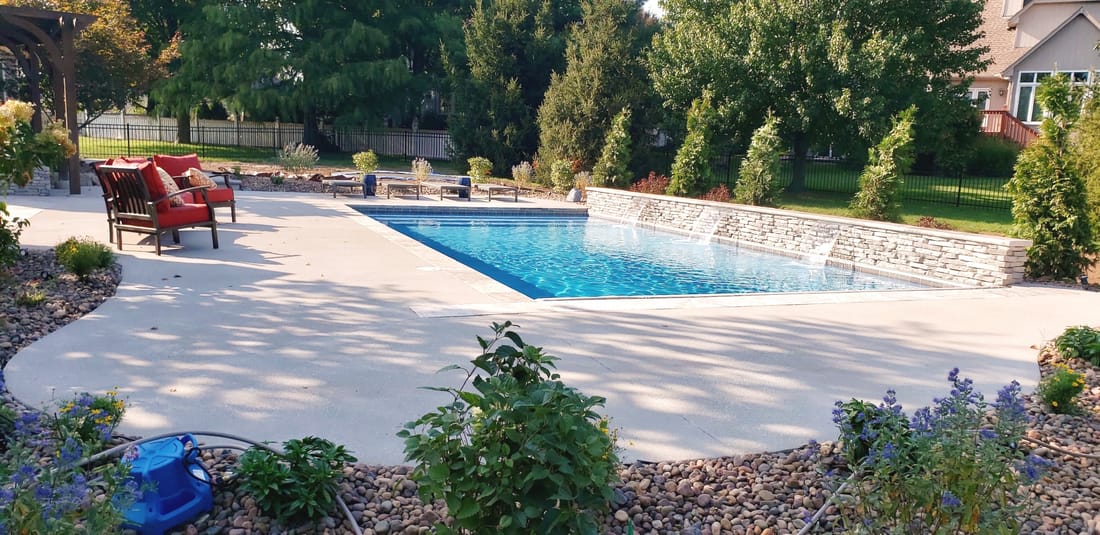 Modern swimming pool with a paver patio and landscaped beds