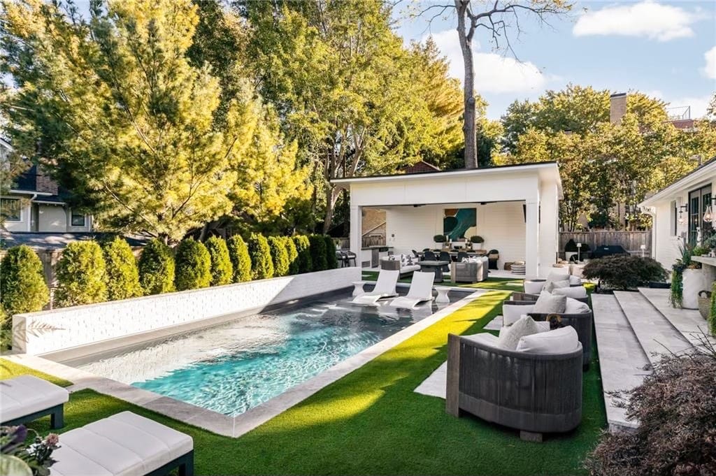 Swimming pool beside a cabana with covered lounge seating