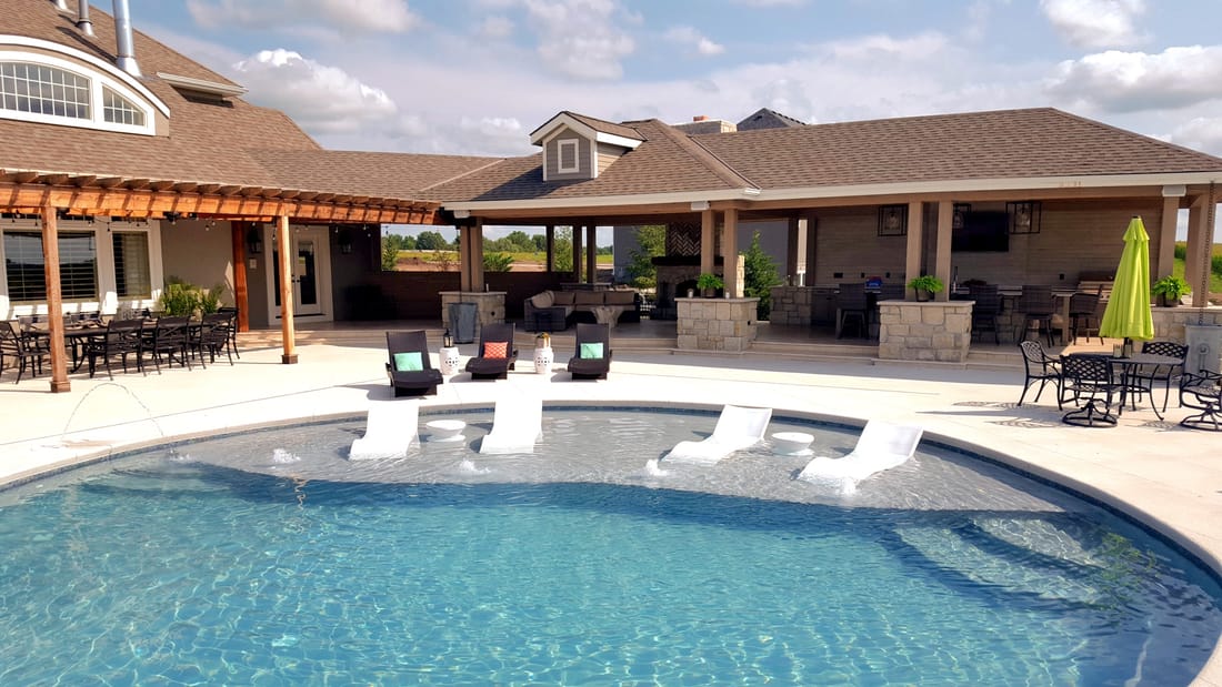 Large swimming pool with a covered patio and brick pergola